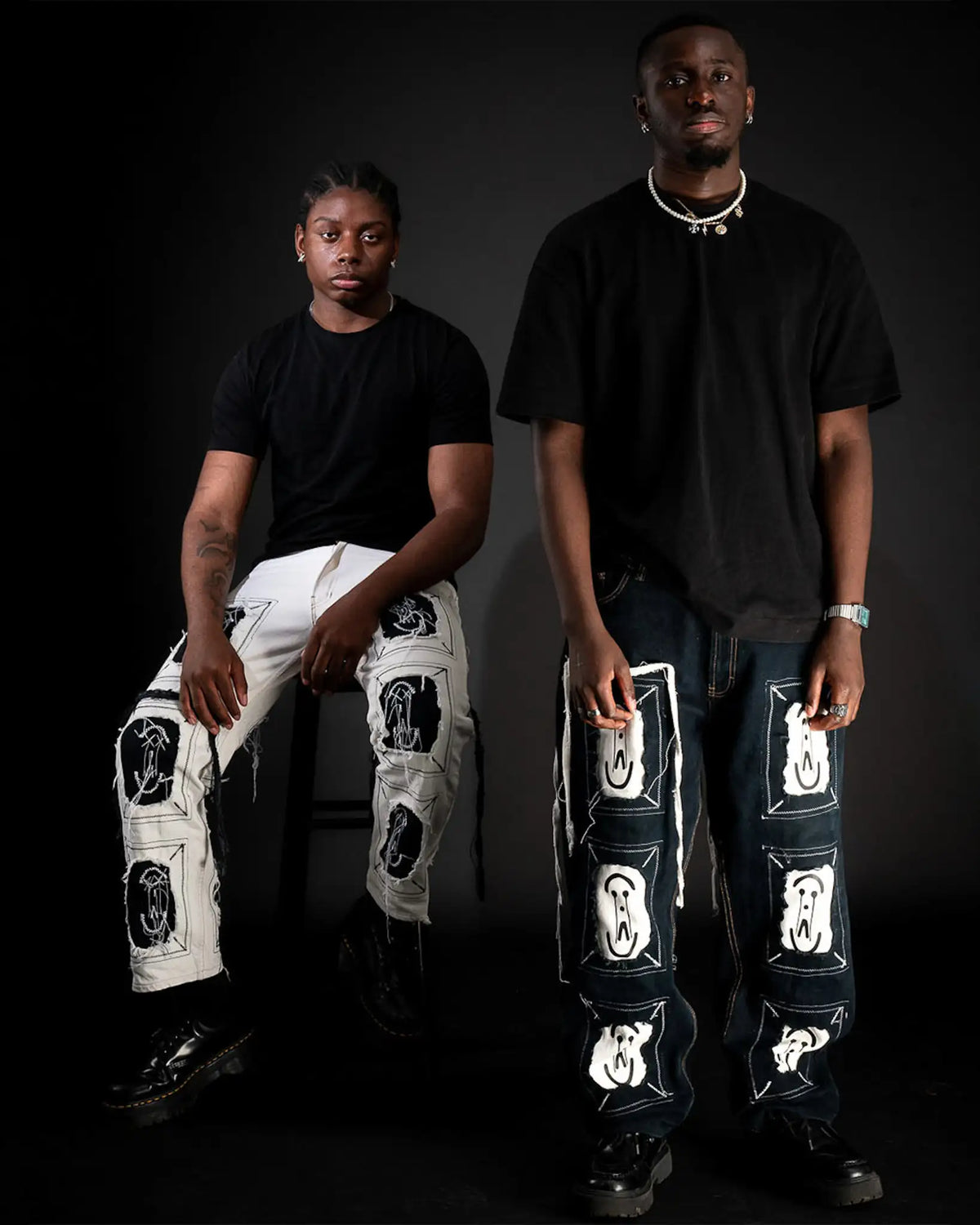 Black & White Framed Logo by Prototypesparis  designs from the ‘DNA’ Capsule worn by two models, captured on a dark backdrop.