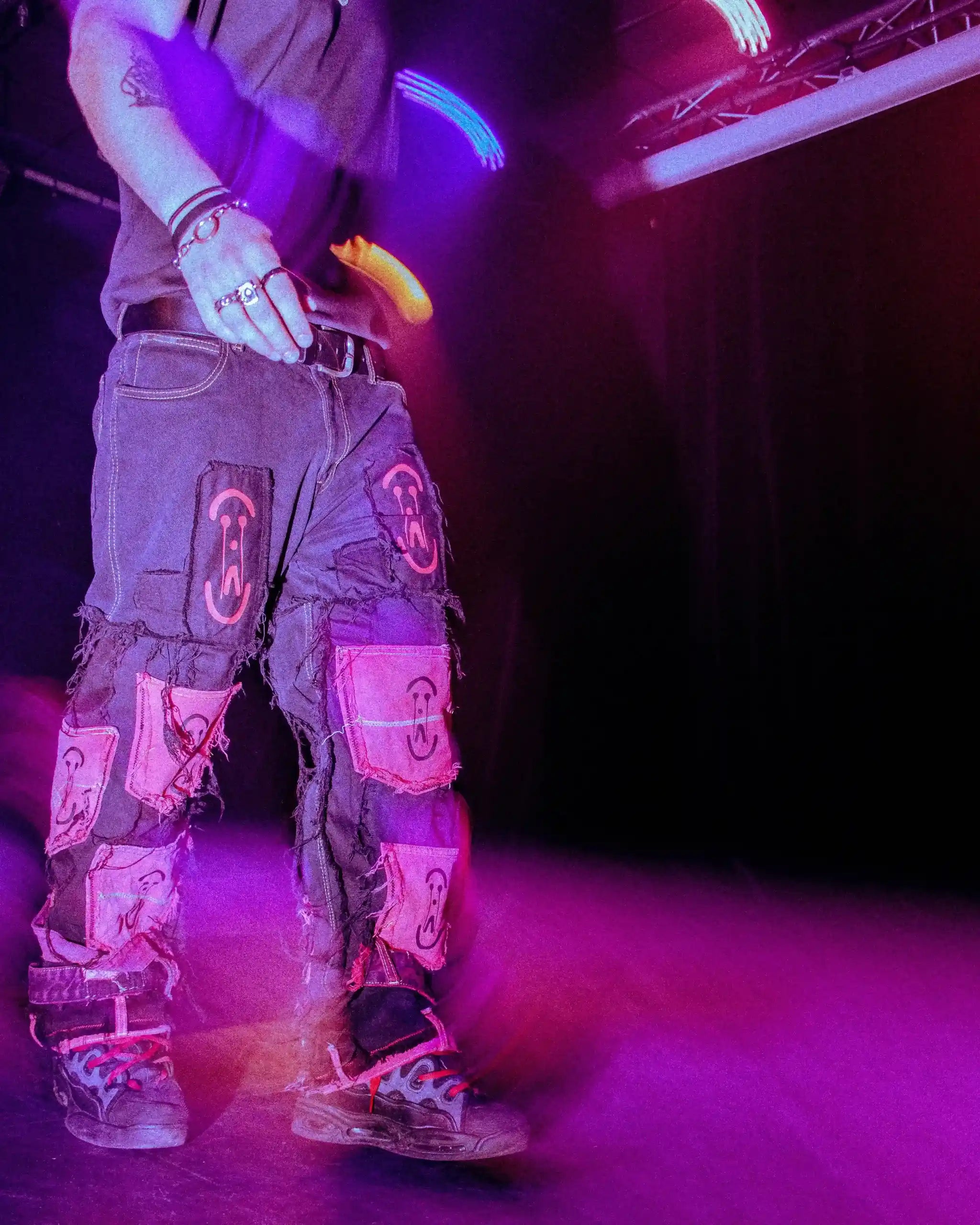 Fashion show close-up: PrototypesParis black denim with iconic logo patches—handmade upcycled jeans, motion blur.