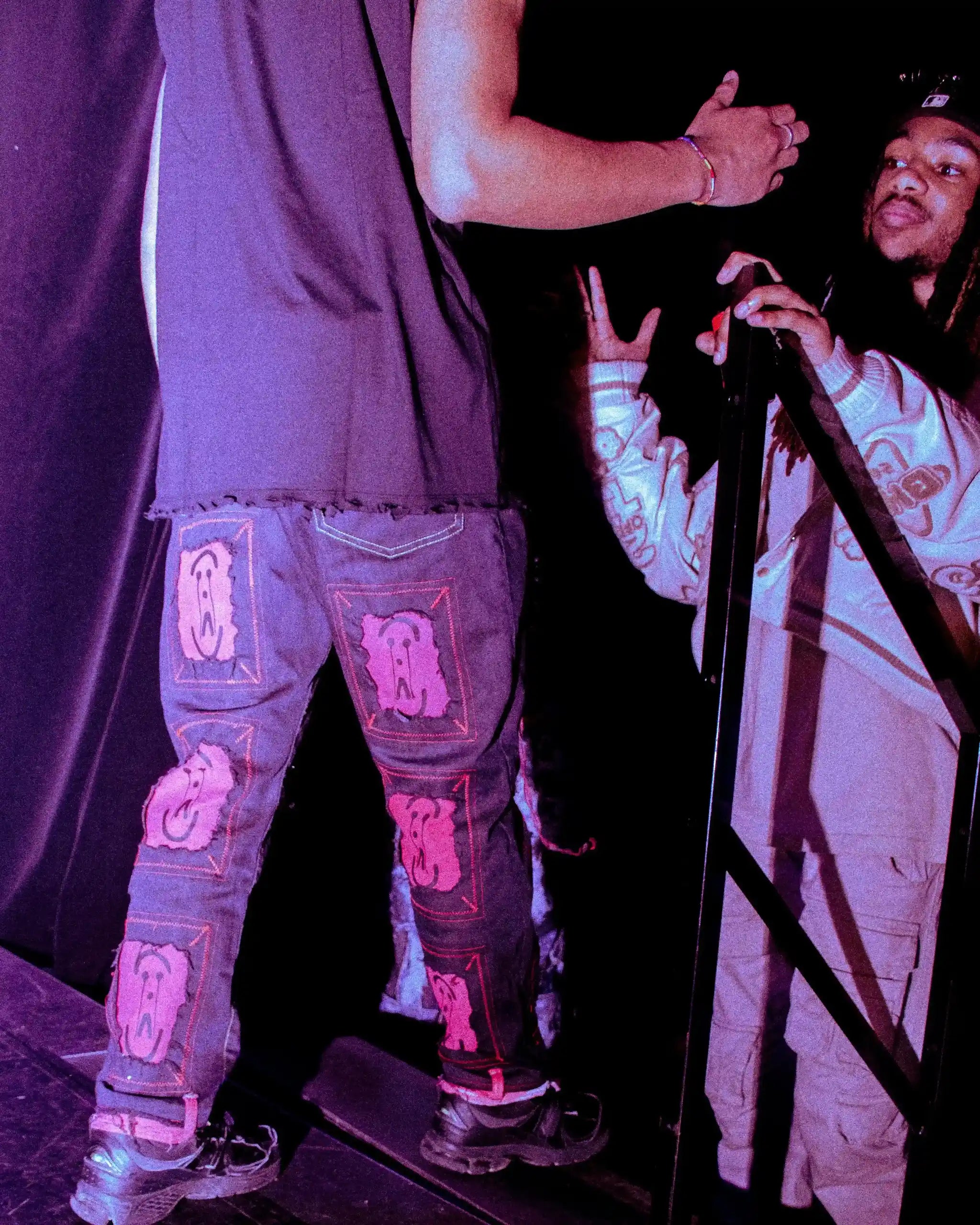 Backstage fashion show: PrototypesParis black denim with iconic logo patches—handcrafted upcycled jeans, rear view.
