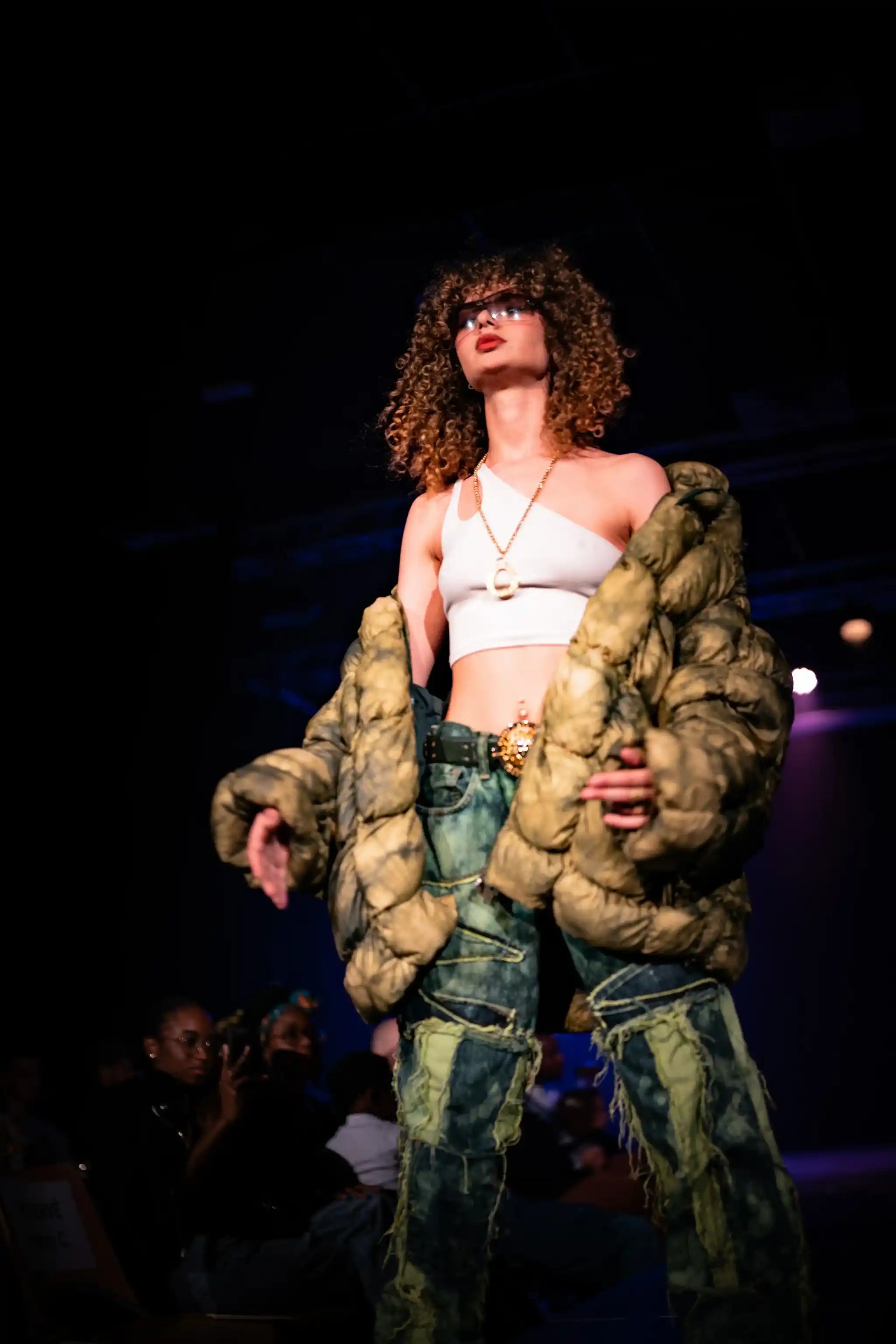 PrototypesParis fashion show: green distressed patchwork denim with quilted puffer—upcycled raw-edge jeans, front view.